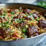 Freshly cooked Comforting Ground Beef Orzo Dinner served in a bowl, featuring tender pasta, sweet bell peppers, and peas.