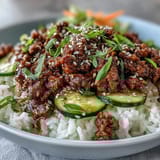 Hot ground beef glazed in a spicy gochujang sauce in a skillet for an Easy Korean Beef Bowl.