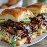 Tender, slow-cooked brisket with zesty BBQ sauce and crisp cabbage slaw served on warm slider buns for celebrations.