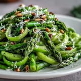 A vibrant vegetarian side featuring shaved asparagus, tangy lemon, and nutty Parmesan, perfect for light lunches.  