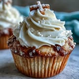 Tender Communion cupcakes frosted artfully with buttercream and an edible white cross charm.