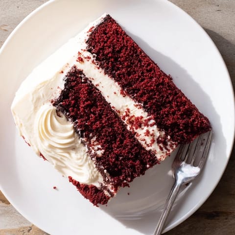 A classic Southern Red Velvet Cake generously covered in fluffy, tangy cream cheese frosting.