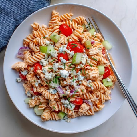 Freshly made Buffalo Chicken Pasta Salad featuring rotini pasta, tender chicken, and herbs in a light dressing.