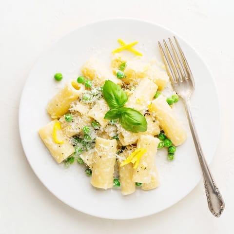 Heaping bowl of pea and lemon ricotta pasta with tender green peas and al dente rigatoni tossed in a silky citrus sauce.  