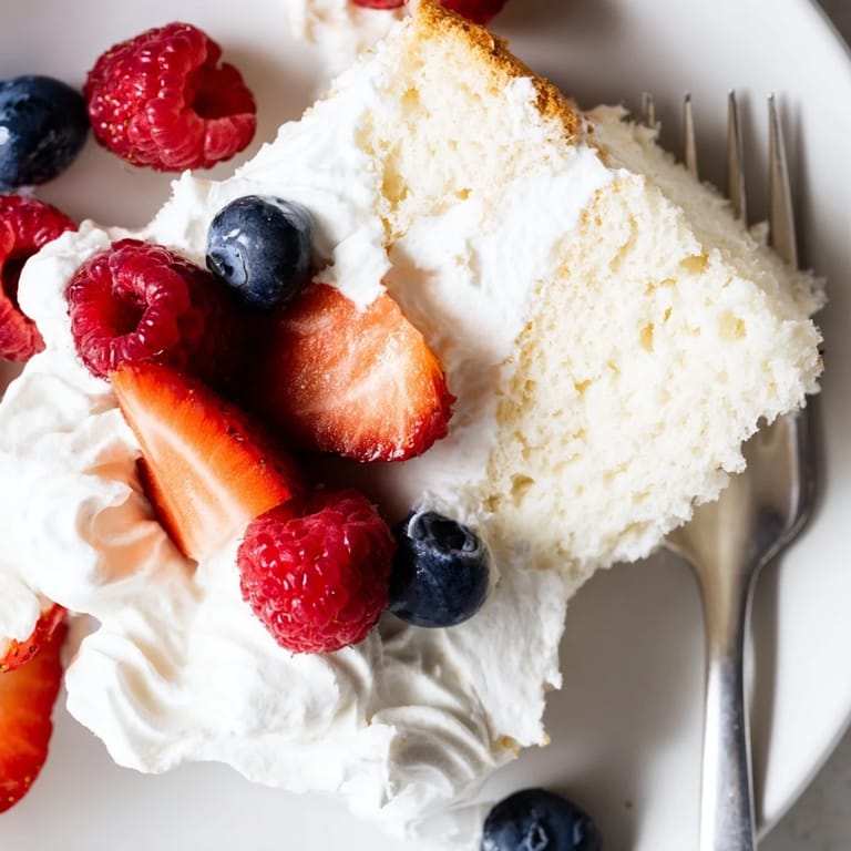 Light and airy Angel Food Cake baked in a tube pan, perfect for a delicate dessert served with fruit.
