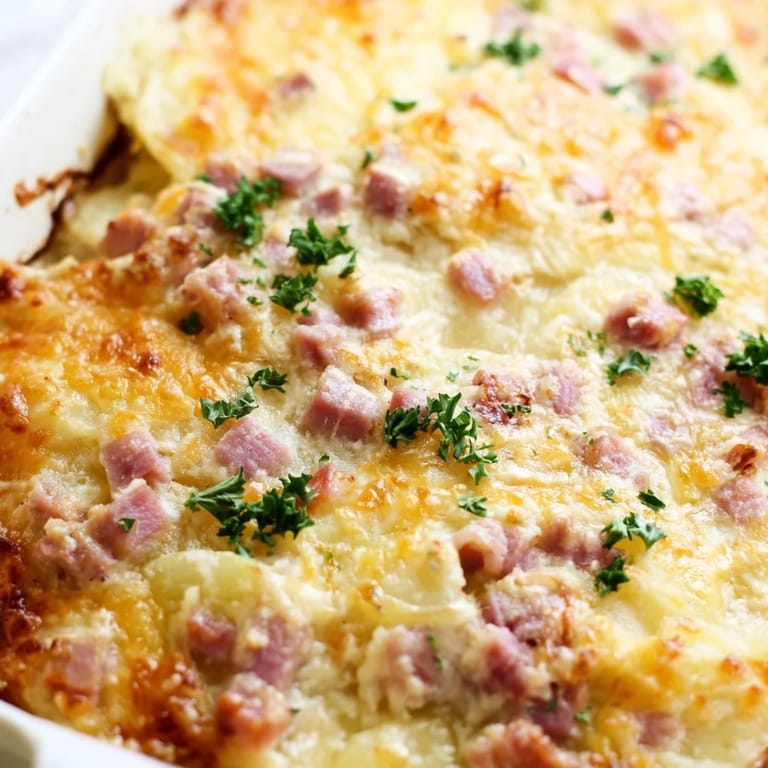 Homemade Scalloped Potatoes with Ham served hot in a ceramic dish, ideal for a comforting family dinner or holiday meal.