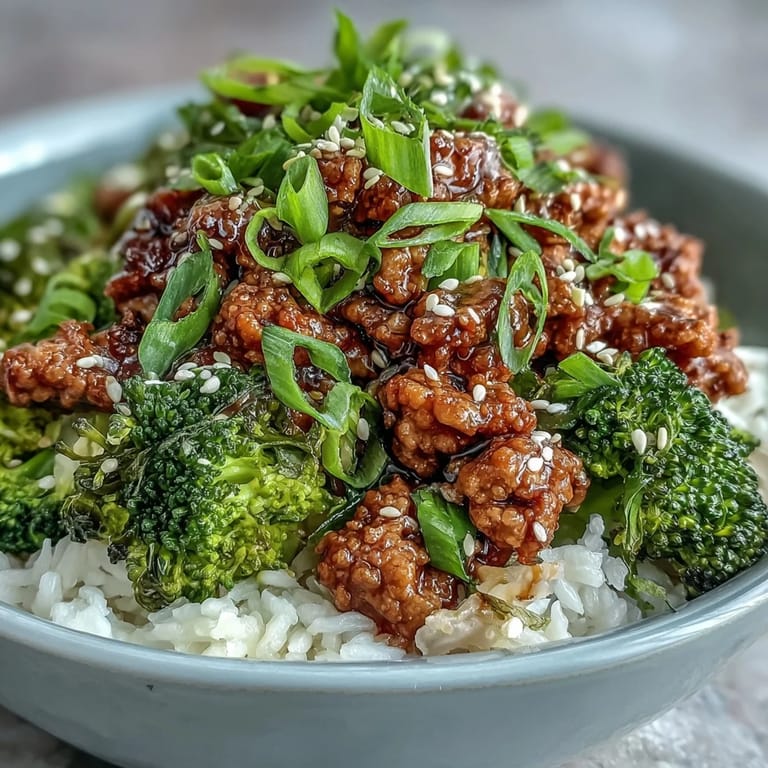 Close-up of Sweet and Spicy Turkey Broccoli Bowls, highlighting saucy ground turkey, vibrant green broccoli florets, fluffy rice, and a garnish of sesame seeds and fresh green onions.