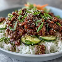 Hot ground beef glazed in a spicy gochujang sauce in a skillet for an Easy Korean Beef Bowl.