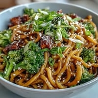 Vibrant Asian Teriyaki Noodle Bowl with tender egg noodles, crisp steamed broccoli, and carrots tossed in a glossy sauce.