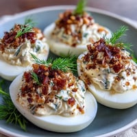 Smoked salmon deviled eggs with everything seasoning, creamy and savory, topped with fresh dill and crunchy bagel mix.
