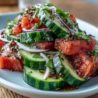 Vibrant watermelon cucumber salad with Tajin, a cool, zesty summer delight.