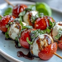 Mini Caprese salad skewers bursting with fresh tomatoes, mozzarella, and basil.